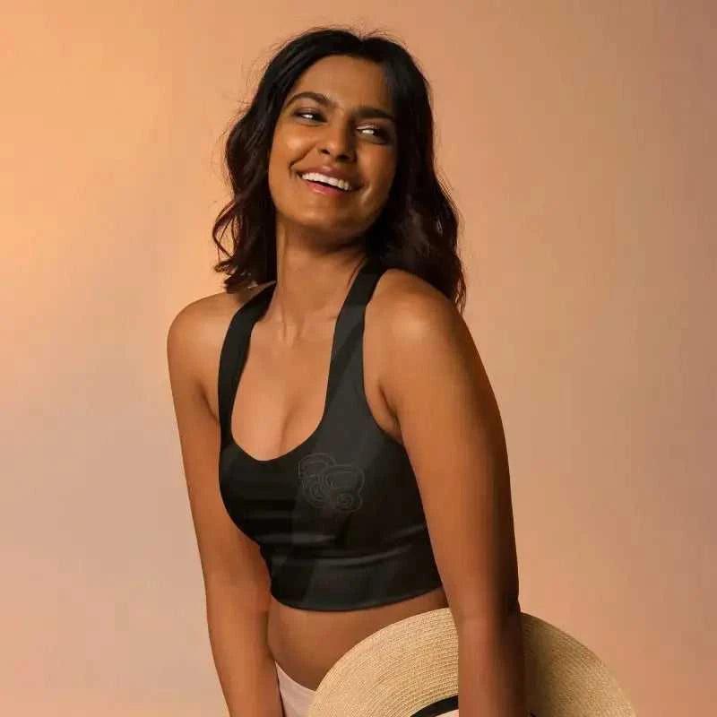 Smiling person in a black longline sports bra with a warm backdrop