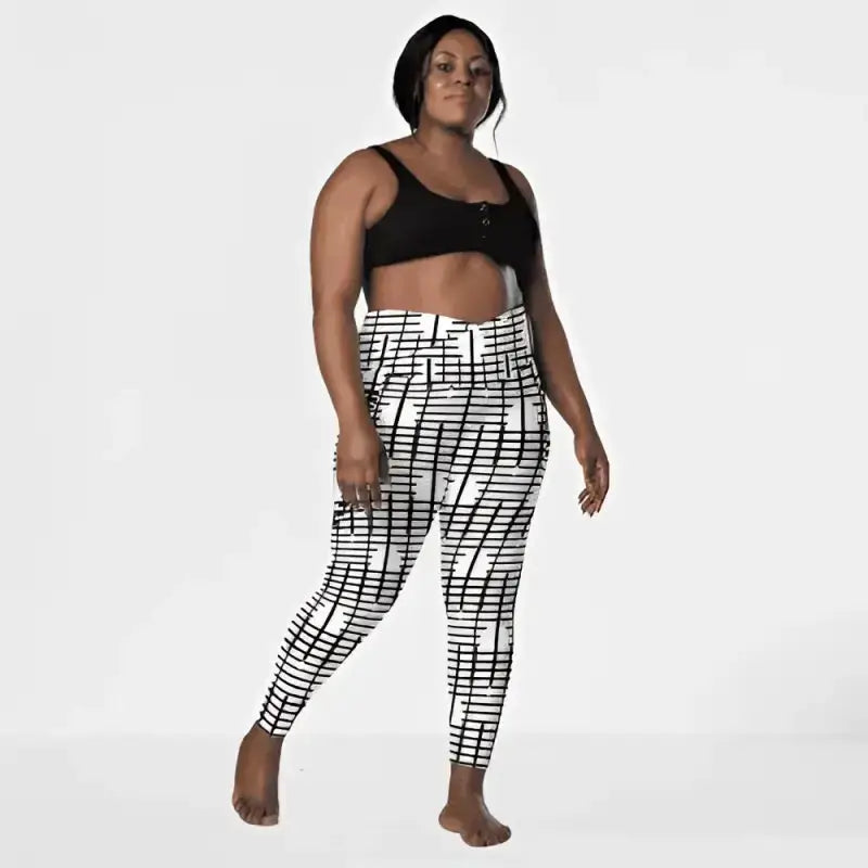 High-waisted black recycled crossover leggings with geometric grid pattern and pockets