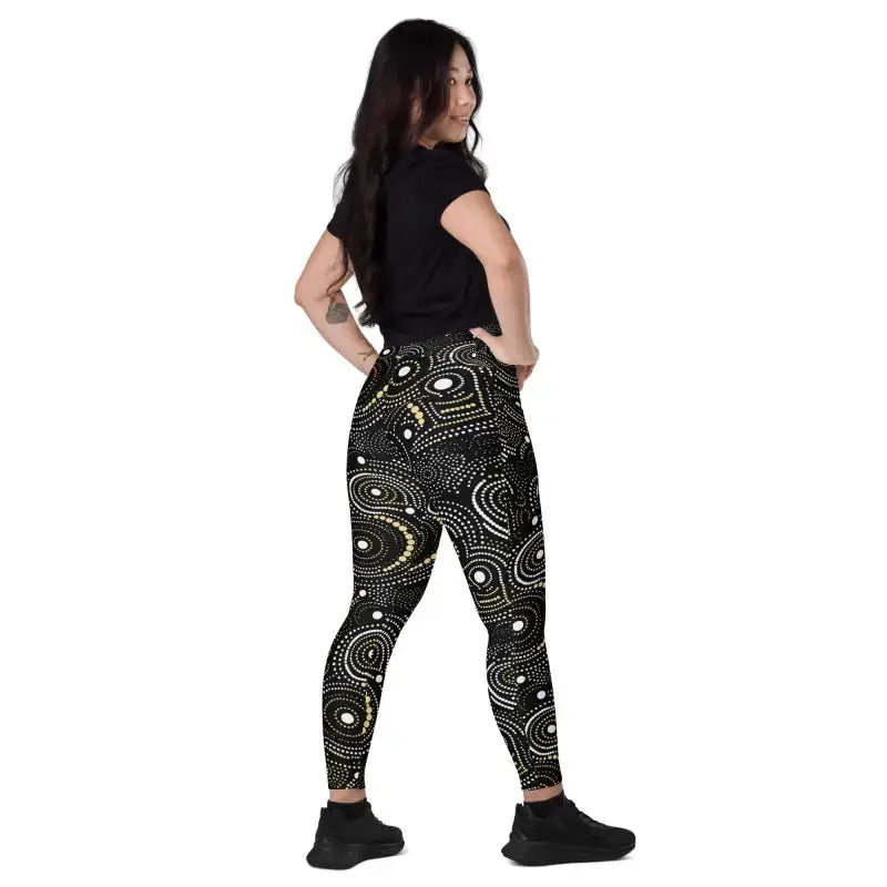 Woman wearing stylish crossover leggings in black and gold, perfect for workout or plus size activewear