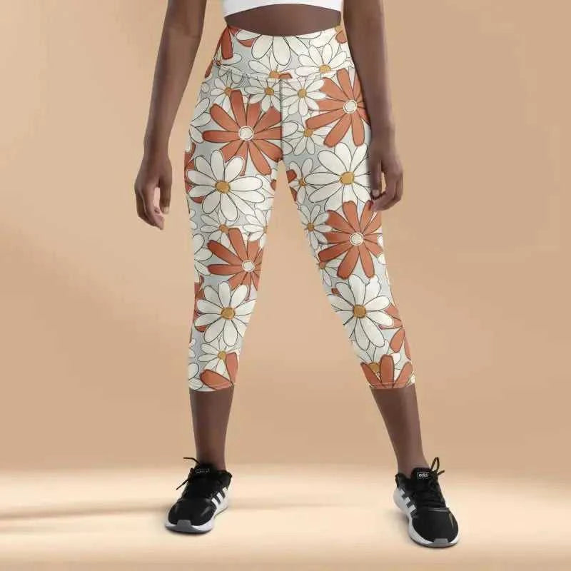 Floral print capri-length athletic leggings with orange and white daisy patterns.