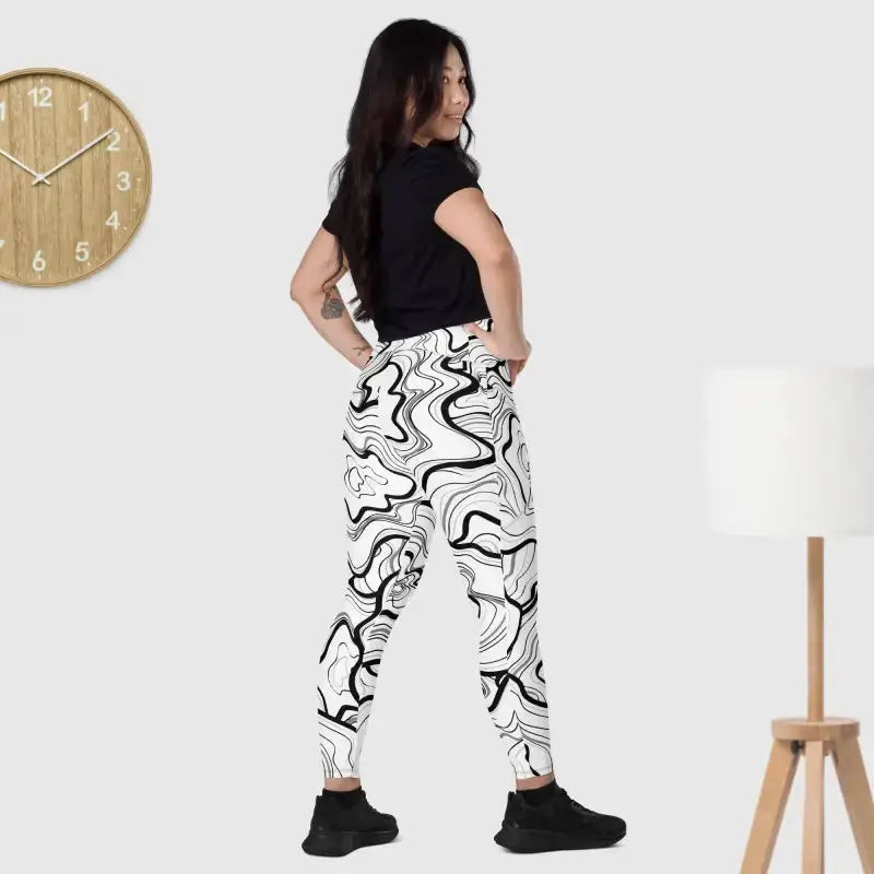 Black fitness leggings with a phone pocket, styled with black and white patterned joggers