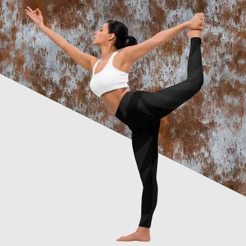 Dancer in standing split wearing black yoga leggings and white crop top for yoga practice