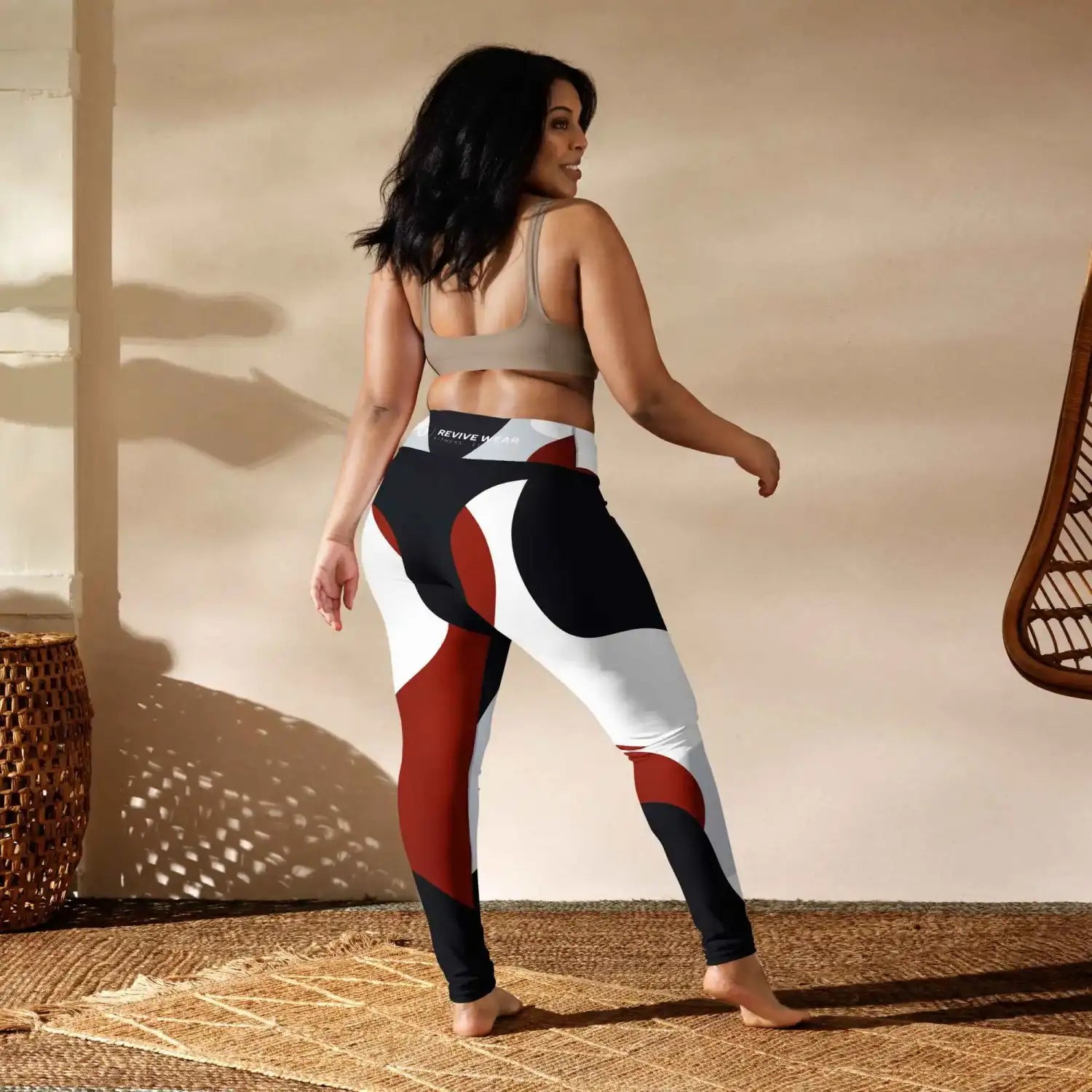 Color-blocked athletic leggings in black, white, and rust red with an abstract geometric pattern.