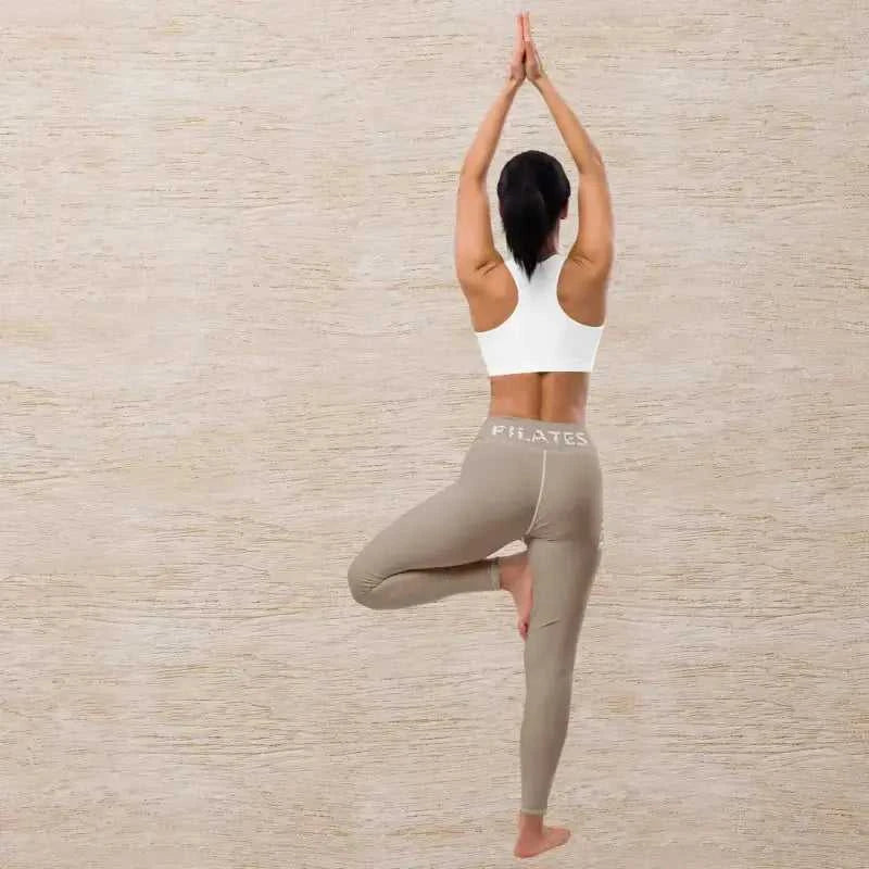 Woman in tree pose wearing comfy khaki pilates leggings for a perfect workout look