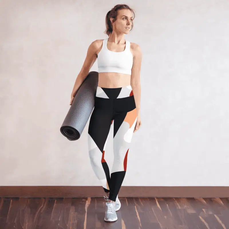 Athletic person in white sports bra and geometric leggings with a yoga mat for workouts